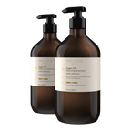 Two bottles of Theorie Argan Oil Shampoo and Conditioner on a white background